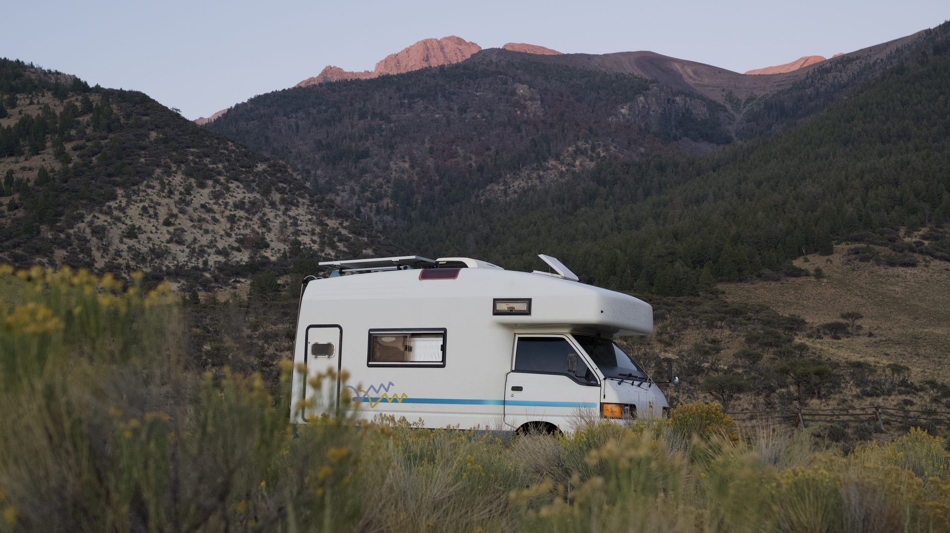 Camper van parked in the mountains at sunset